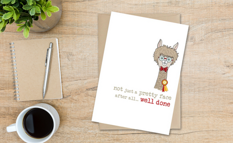 Funny well done card for passing exams with a cartoon llama with round circle glasses on and a red bow tie with a matching badge “not just a pretty face after all… well done”